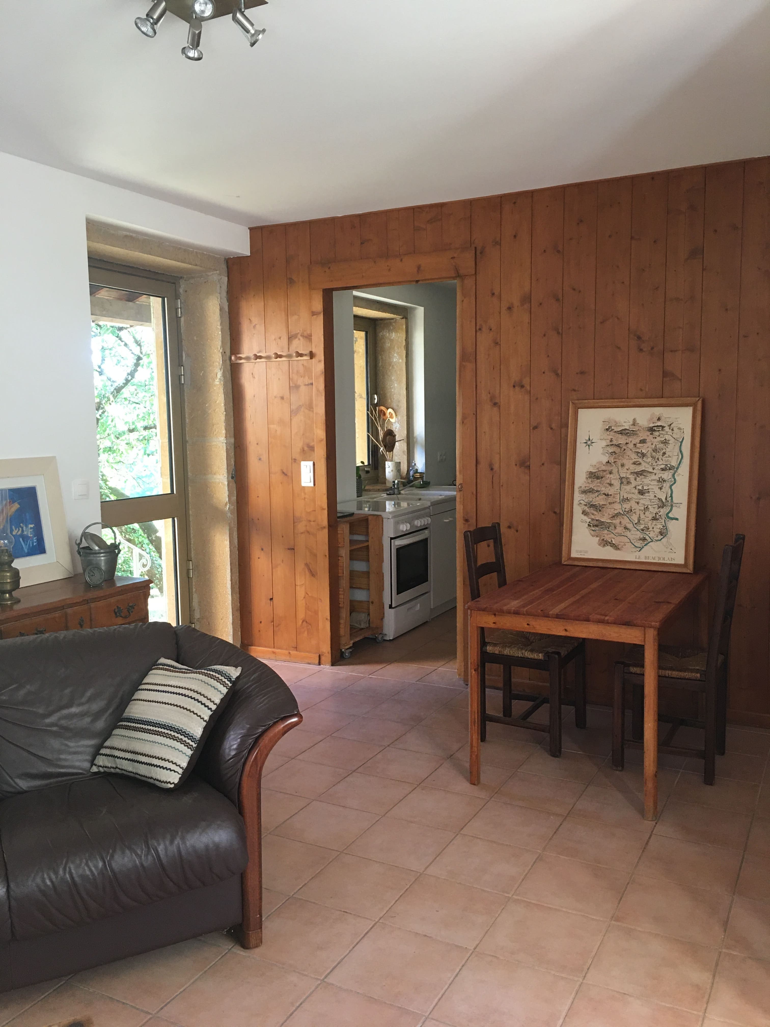 Salon cathédrale lumineux du Cottage des Pierres Dorées avec poutres apparentes et canapés confortables