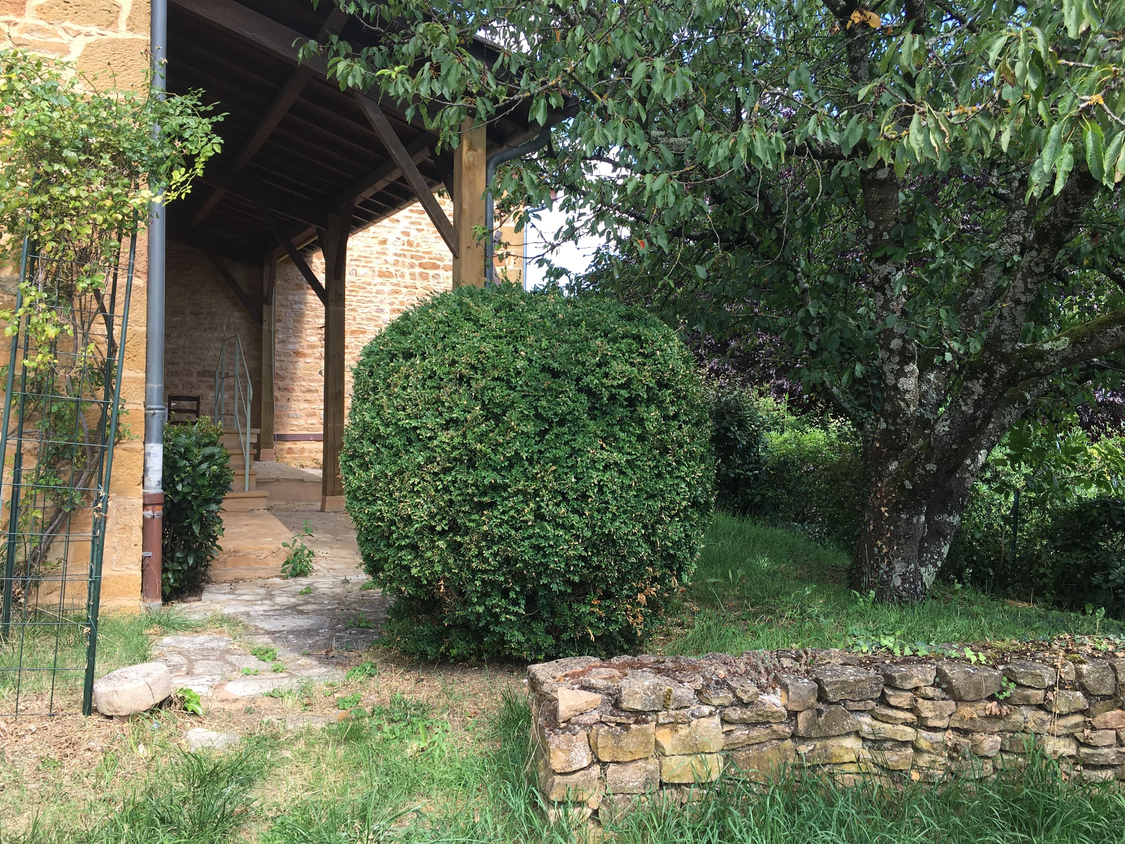 Entrée fleurie et accueillante de la cour intérieure du Cottage des Pierres Dorées