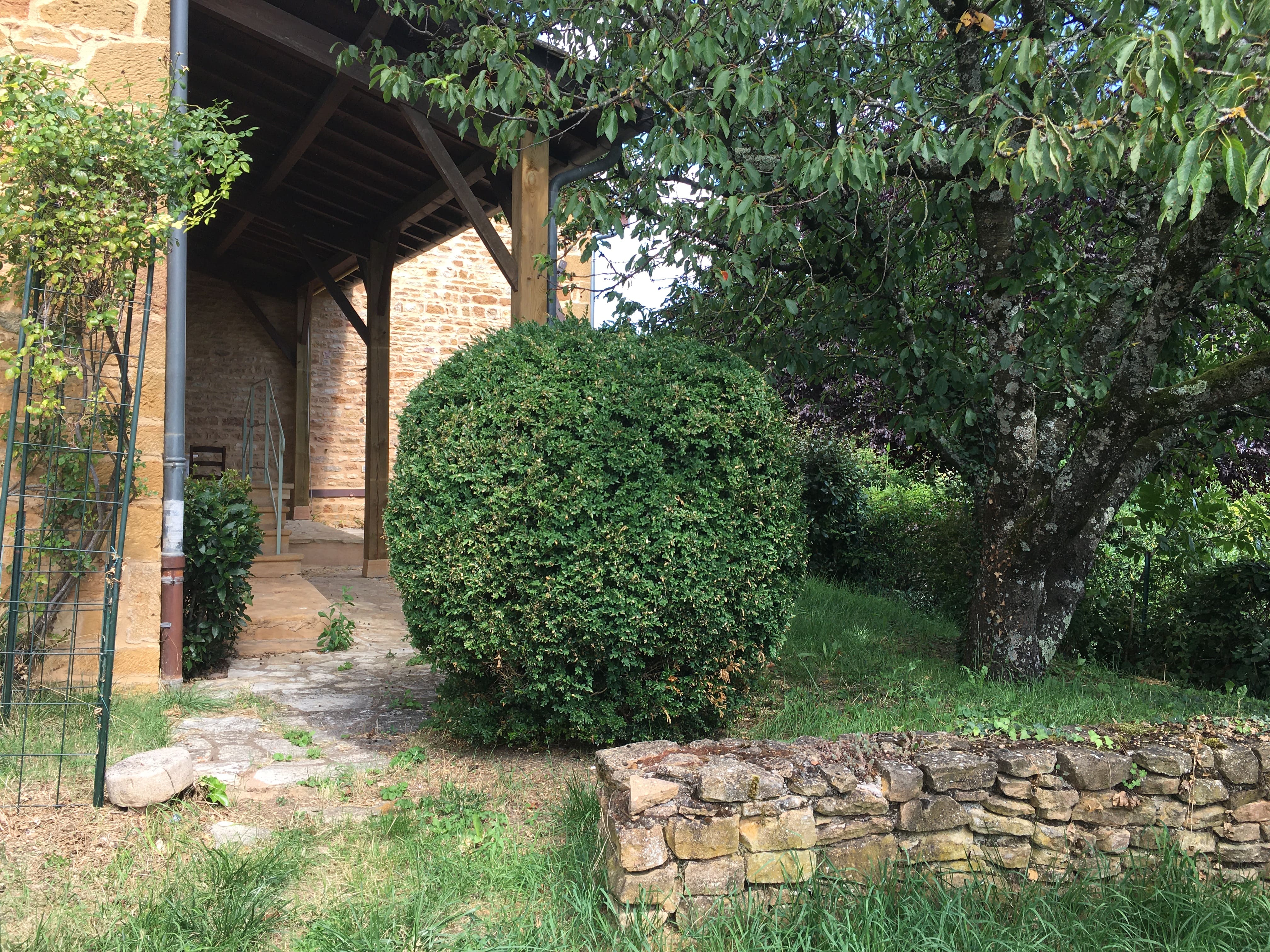 Entrée fleurie et accueillante de la cour intérieure du Cottage des Pierres Dorées